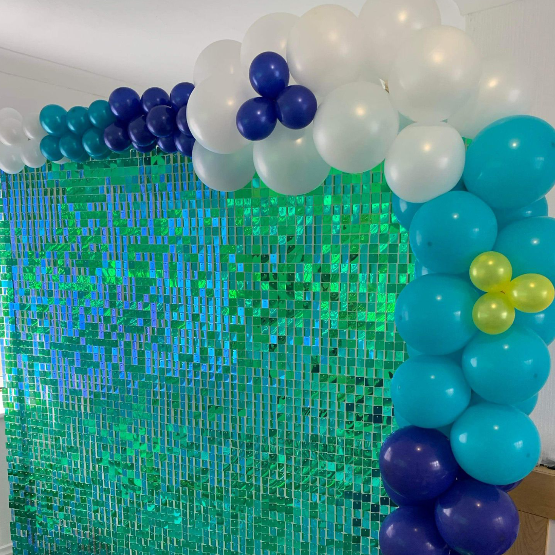 Green glitter wall with blue and white balloons