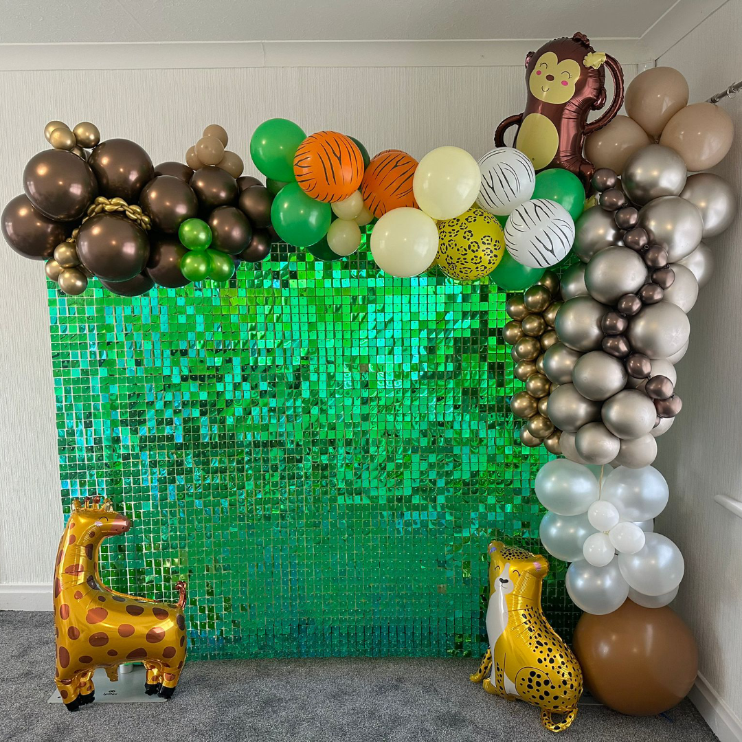 Green glitter wall with jungle theme balloons