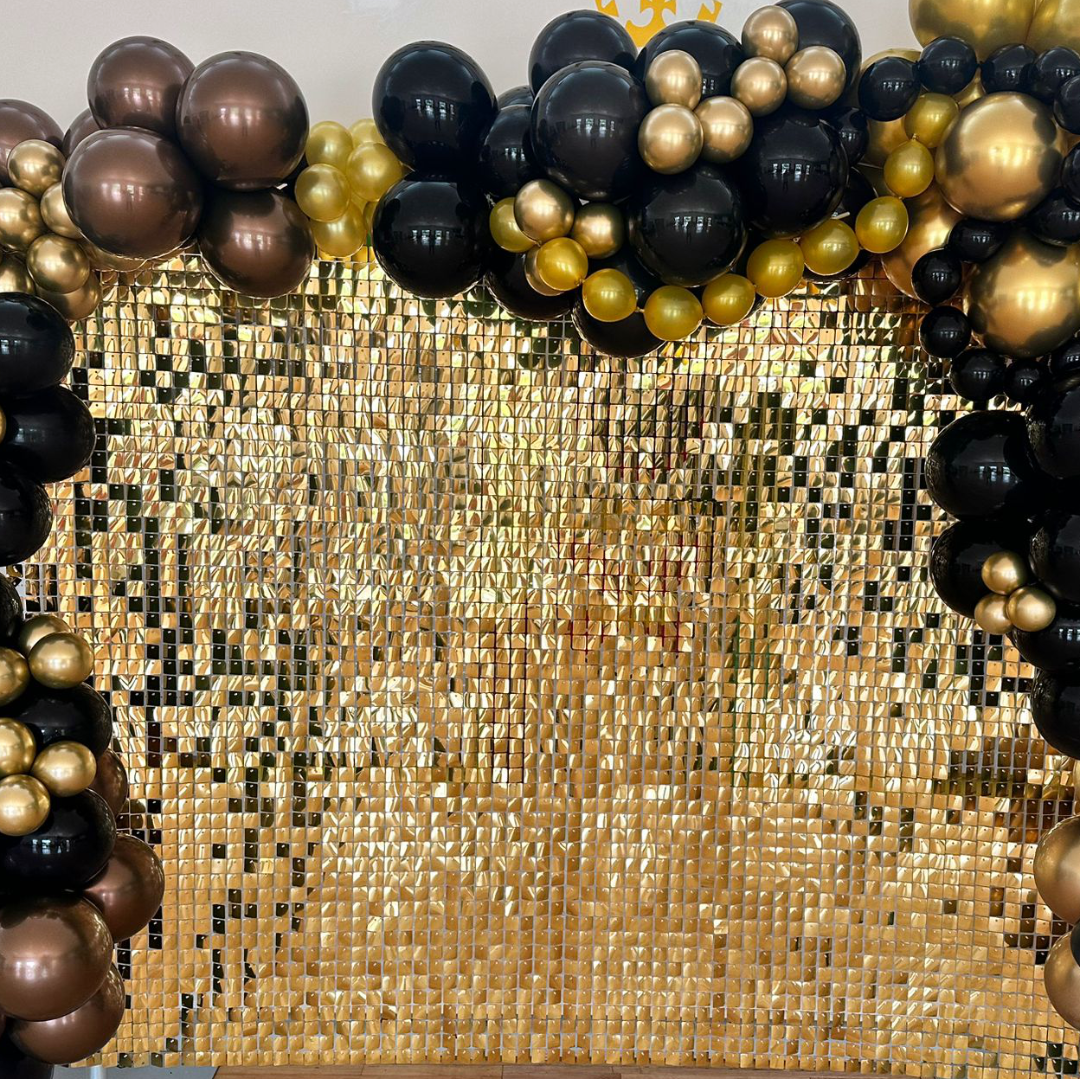 Black and gold balloon display with gold glitter wall